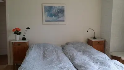 a bedroom with a bed and two night stands with lamps at Bed & Breakfast i Vorupør in Nørre Vorupør