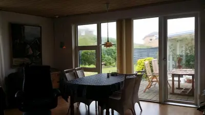 a dining room with a table and chairs and a sliding glass door at Bed & Breakfast i Vorupør in Nørre Vorupør