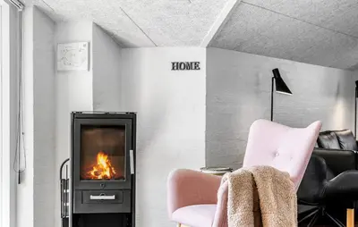 a living room with a fireplace and a chair at Amazing Home In Thisted With Sauna in Thisted