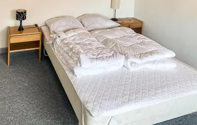 a bed with white sheets and pillows on it at Amazing Home In Harboøre With Wifi in Harboør