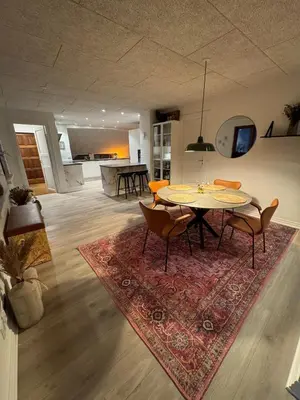 a dining room with a table and chairs on a rug at Villa Centrum in Holstebro