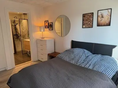 a bedroom with a bed and a mirror on the wall at Villa Centrum in Holstebro