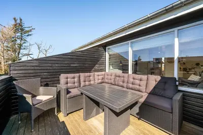 a patio with a table and chairs on a deck at Pirupshvarrevej 5A in Blokhus