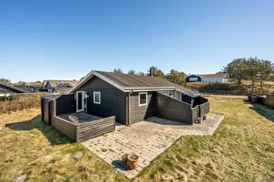a small house sitting on top of a field at Pirupshvarrevej 5A in Blokhus