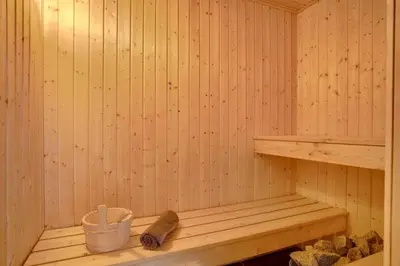 a sauna with a wooden bench and a bucket at Laustvej 3 in Saltum