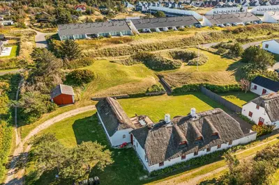 an aerial view of an old farmhouse with a grass roof at 3009Møllehuset, Begge Huse in Blokhus