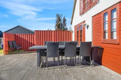 a table and chairs on a wooden deck at 3008Møllehuset Baghusetanneks in Blokhus
