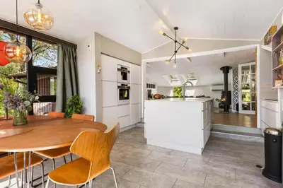 a kitchen and dining room with a wooden table and chairs at Granlien 3, A Holiday Home With Soul And Charm! in Blokhus