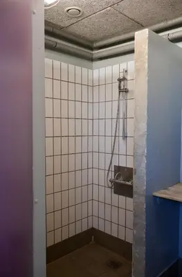 a bathroom with a toilet with white tiles at Aalborg Hytteø in Aalborg