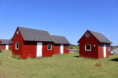 two red buildings in a field of grass at Aalborg Hytteø in Aalborg