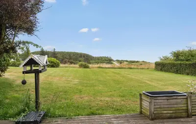 a bird feeder in a yard with a field at Amazing Home In Spøttrup in Spottrup