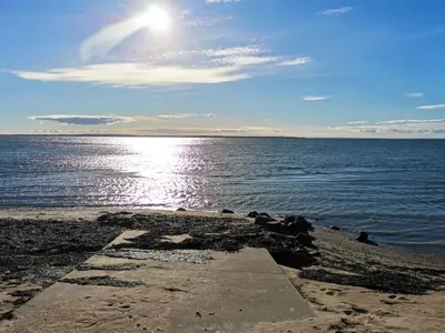 a beach with the sun shining on the water at 6 person holiday home in Thyholm in Thyholm