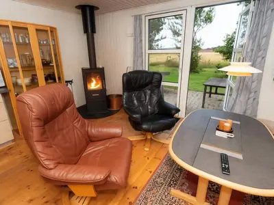 a living room with a table and two chairs and a coffee table at 6 person holiday home in Thyholm in Thyholm