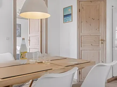 a dining room with a table and white chairs at Holiday Home Antine - 400m from the sea by Interhome in Thyborøn