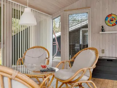 a porch with two chairs and a glass table at Holiday Home Iris - 200m to the fjord by Interhome in Thyholm