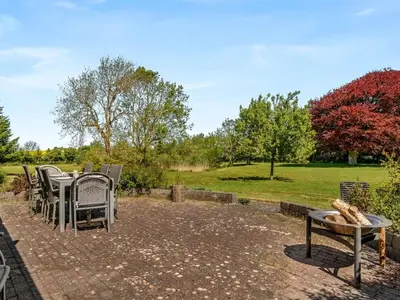 a patio with tables and chairs in a park at Holiday Home Elia - 5km to the fjord by Interhome in Spottrup