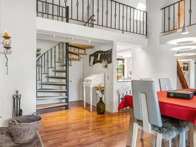 a dining room and kitchen with a red table and stairs at Holiday Home Elia - 5km to the fjord by Interhome in Spottrup