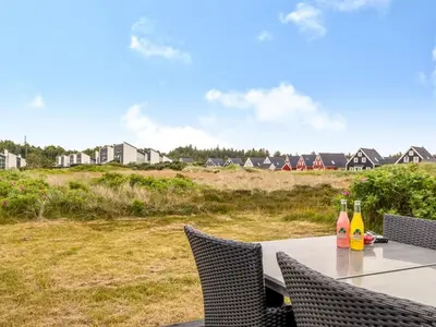 a table with two bottles of wine sitting on it at Holiday Home Nis - 900m from the sea by Interhome in Blokhus