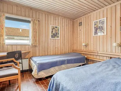 a bedroom with two beds and a desk and a window at Holiday Home Aike - 1km from the sea by Interhome in Pandrup
