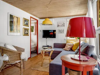 a living room with a couch and a red lamp at Holiday Home Goodje - 400m from the sea by Interhome in Blokhus
