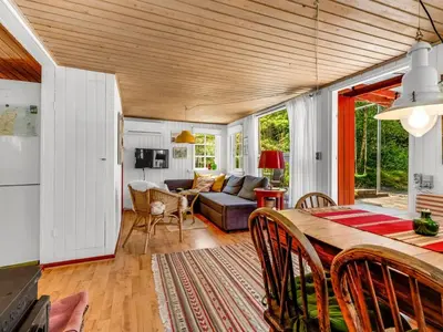 a living room with a table and a couch at Holiday Home Goodje - 400m from the sea by Interhome in Blokhus