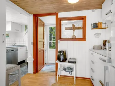 a kitchen with white walls and a wooden ceiling at Holiday Home Goodje - 400m from the sea by Interhome in Blokhus