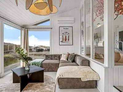 a living room with a couch and a large window at Holiday Home Marcus - 500m from the sea by Interhome in Saltum