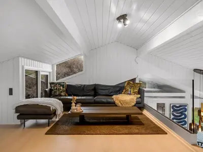 a living room with a black couch and a table at Holiday Home Marcus - 500m from the sea by Interhome in Saltum