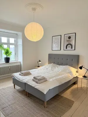 a bedroom with a bed and a potted plant at Cozy pearl downtown Viborg in Viborg