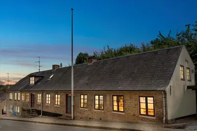 an old brick building with its lights on at Villa Bakkely in Lemvig
