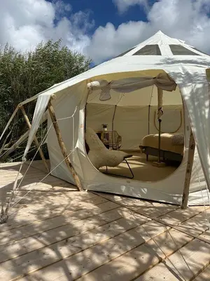 a white tent with a chair in it at Agger Glamping - Lyngheden in Vestervig