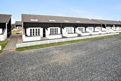a black and white building with a white fence at 212-Vestervig-Havnevej-1-lejl-12 in Vestervig
