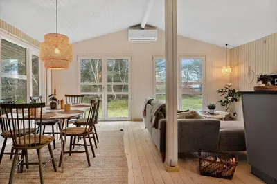 a living room with a couch and a table and chairs at 1067-Thisted-Gra-Rimme-7 in Torsted