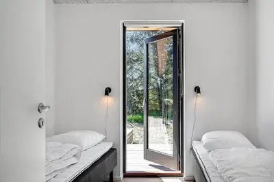a room with two beds and a door to a patio at 1323-Thisted-Fiskervej-96 in Thisted