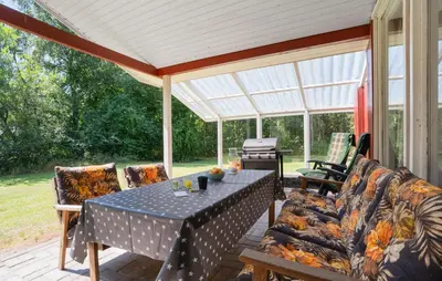 a screened porch with a table and chairs and a piano at 3 Bedroom Amazing Home In Aabybro in Åbybro