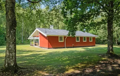 a red barn with trees in front of it at 3 Bedroom Amazing Home In Aabybro in Åbybro