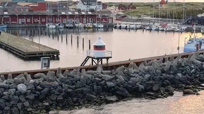 a harbor with a lighthouse and boats in the water at Ny lækker lejlighed på Havnen in Thyborøn