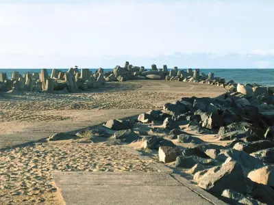 a beach with a bunch of rocks and the ocean at 4 star holiday home in Thyborøn in Thyborøn