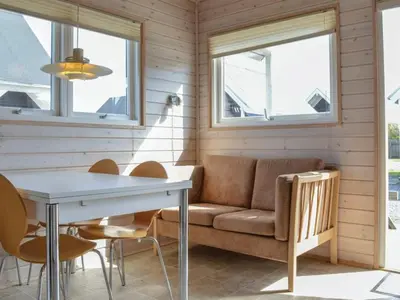 a living room with a couch and a table and chairs at 4 star holiday home in Thyborøn in Thyborøn