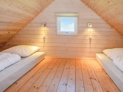 two beds in a wooden room with a window at 4 star holiday home in Thyborøn in Thyborøn