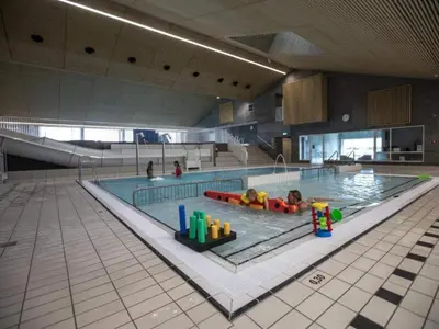 a large swimming pool with two people in it at 4 star holiday home in Thyborøn in Thyborøn