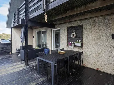 a wooden deck with a table and chairs on a house at 6 person holiday home in Vestervig in Vestervig