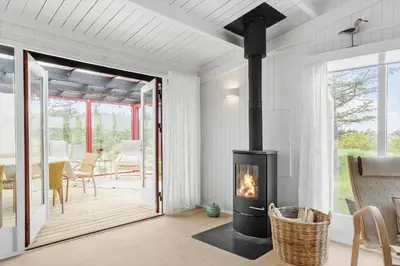 a living room with a fireplace and a patio at 399-Thisted-Sotungevej-21 in Nørre Vorupør