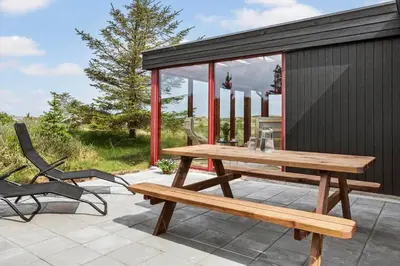 a wooden picnic table and a bench on a patio at 399-Thisted-Sotungevej-21 in Nørre Vorupør