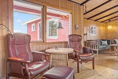 a screened in porch with two chairs and a table at 421-Thisted-Fiskervej-147 in Nørre Vorupør