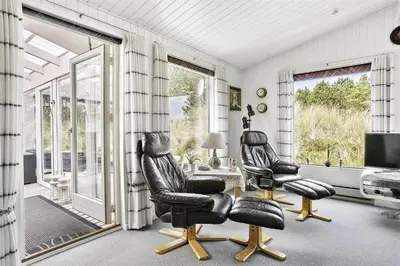 a living room with two black chairs and a table at 880-Thisted-Havtornvej-4 in Thisted