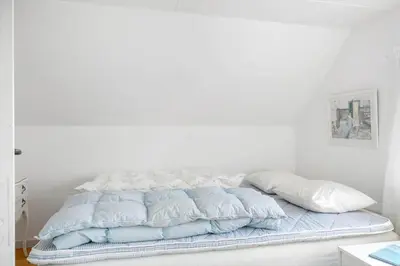 a white bed with blue sheets and pillows on it at 872-Bedsted-Thy-Lyngbyvej-25 in Bedsted Thy