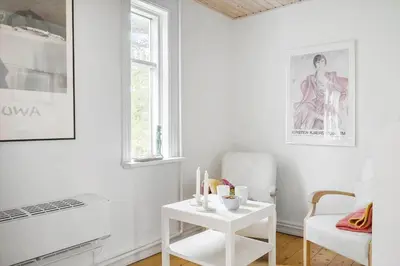 a white living room with a table and a chair at 872-Bedsted-Thy-Lyngbyvej-25 in Bedsted Thy