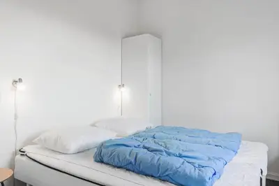 a bed with a blue comforter and two pillows at 1046-Thisted-Johns-Vej-26 in Torsted