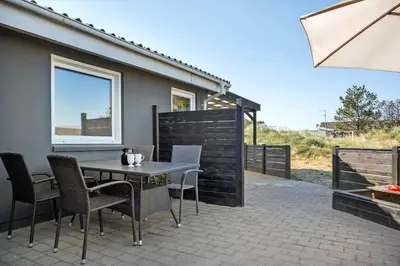 a patio with a table and chairs and a window at 1046-Thisted-Johns-Vej-26 in Torsted